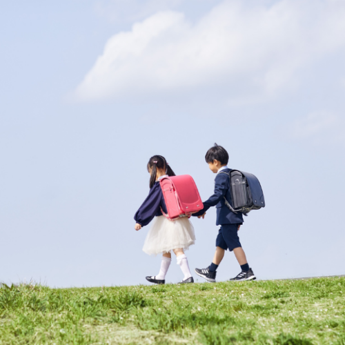 小学生の女の子と男の子が手を繋いで歩いている
