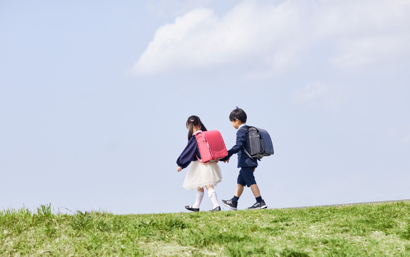 小学生の女の子と男の子が手を繋いで歩いている
