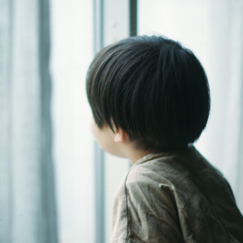 窓を見てぼーっとする男の子