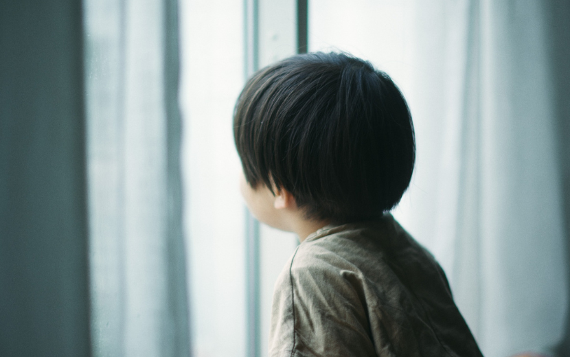 窓を見てぼーっとする男の子